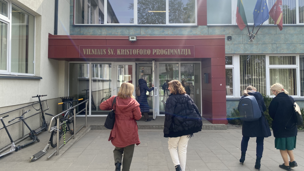 Four people walking up to the door of a school