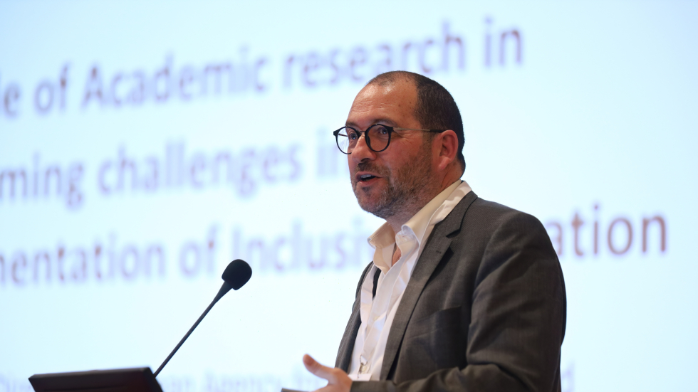 EASNIE Director João Costa speaking at the conference. © UNICEF/University of Patras João Costa standing at a podium and speaking into a microphone