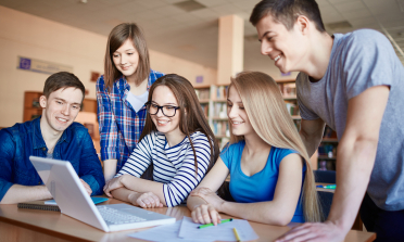 young people around a laptop