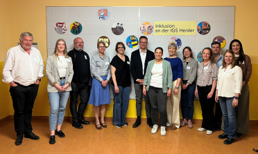 A group of people standing in a school hall