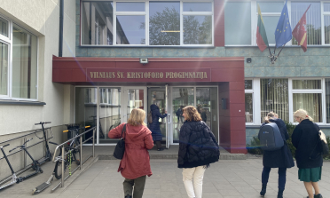 Four people walking up to the door of a school