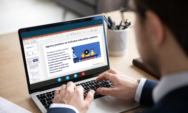A person working on a laptop with the Agency position on inclusive education systems visible on the screen