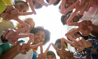 a group of young people touching hands