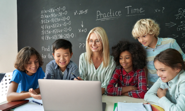 A teacher and five learners using a laptop