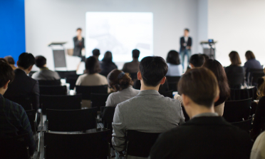 A group of people watching a presentation