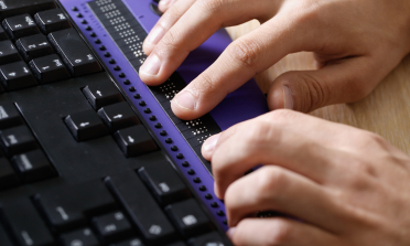 Hands using a Braille keyboard