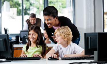 A teacher looks at her pupils' work on a computer screen