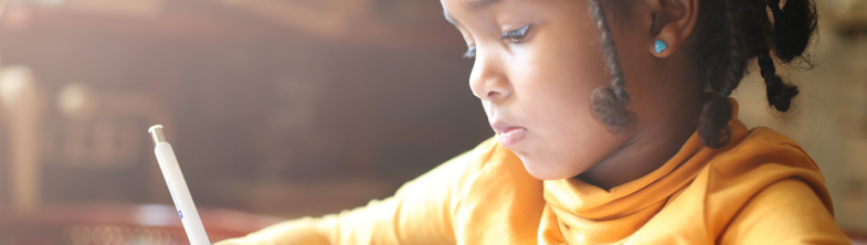 young girl writing at a table