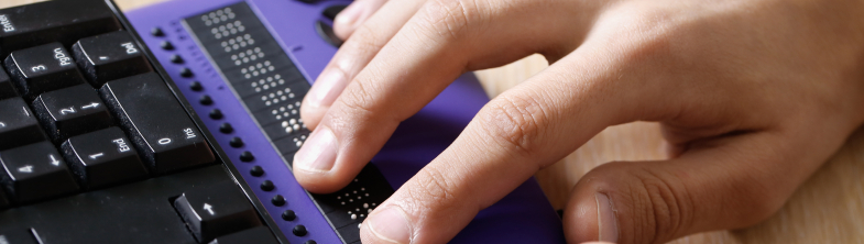 Hands hovering over a Braille keyboard