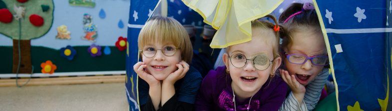 Three children play in a tent