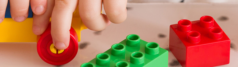 A child's hands playing with colourful bricks