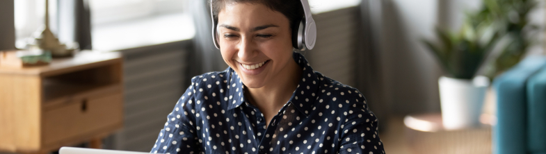 A woman working at a computer wearing headphones