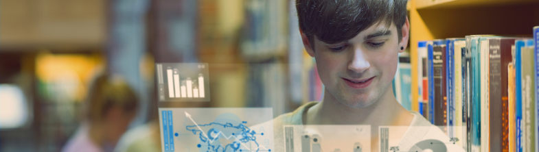 A boy in a library using a tablet showing graphs and charts