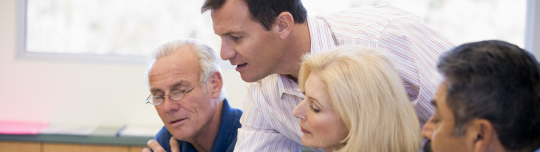 Four people discuss some paperwork