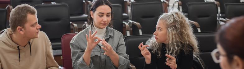 A group of young people communicate using sign language