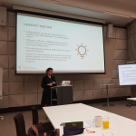 A person presenting at the front of a room