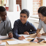 Five young people work around a table together