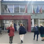 Four people walking up to the door of a school