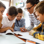 Four children and their teacher look at a workbook together