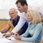 Four people discuss some paperwork