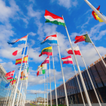 Colourful European flags flying against a blue sky