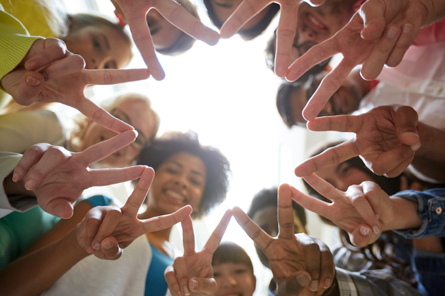 a group of young people touching hands