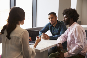Three adults in discussion around a table