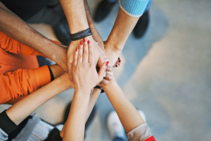 Six people's hands joined together