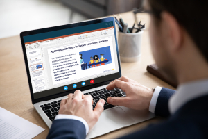 A man looks at a laptop screen with the Agency information displayed on it